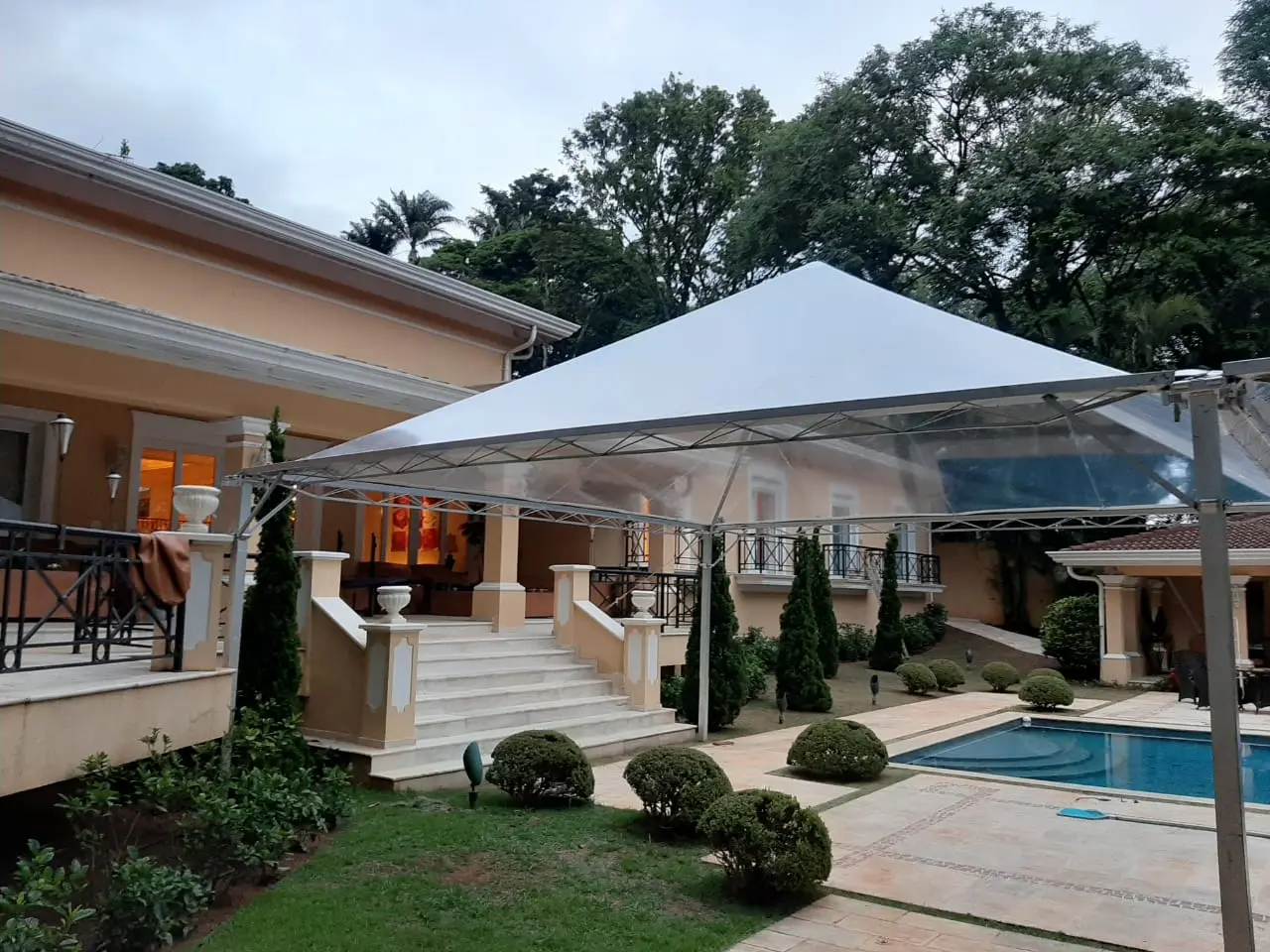 Tenda cristal GS3 montada em casa de alto padrão com piscina, para casamento
